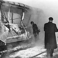 Der ausgebrannte Straßenbahnanhänger, der weiße Belag auf dem Boden ist das Löschpulver vom Erstangriff. | Quelle: Archiv BFM