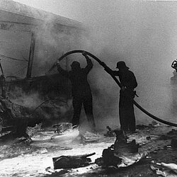 Nachlöscharbeiten mit einem C-Rohr, an den im Erstangriff durch Pulver gelöschten Straßenbahnanhänger | Quelle: Archiv BFM