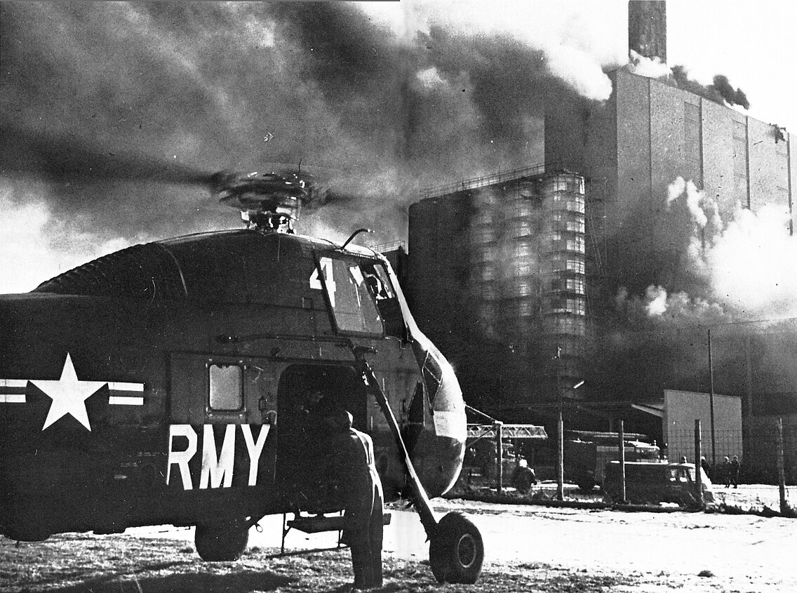 Ein US-Hubschrauber vor dem brennenden Heizkraftwerk in Sendling am 19. Januar 1962