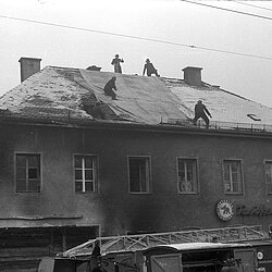 Abdeckung eines beschädigten Daches durch eine große Segeltuchplane am 18.12.1960. | Quelle: Archiv BFM
