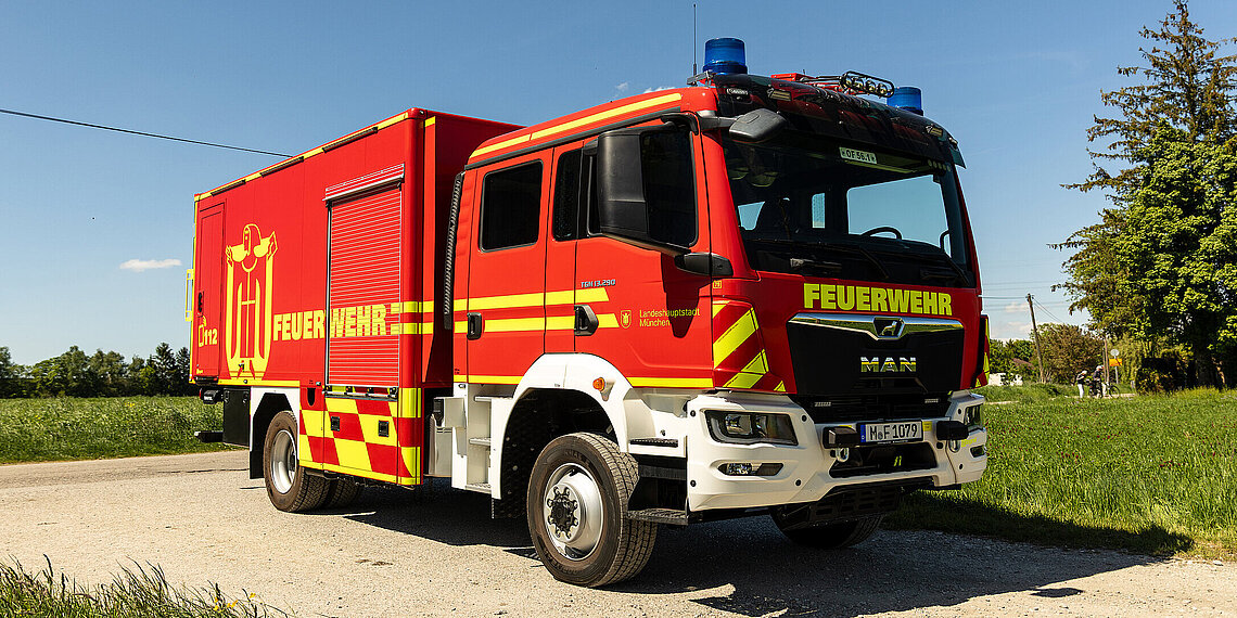 Gerätewagen Logistik auf einem Feldweg bei klarem Himmel